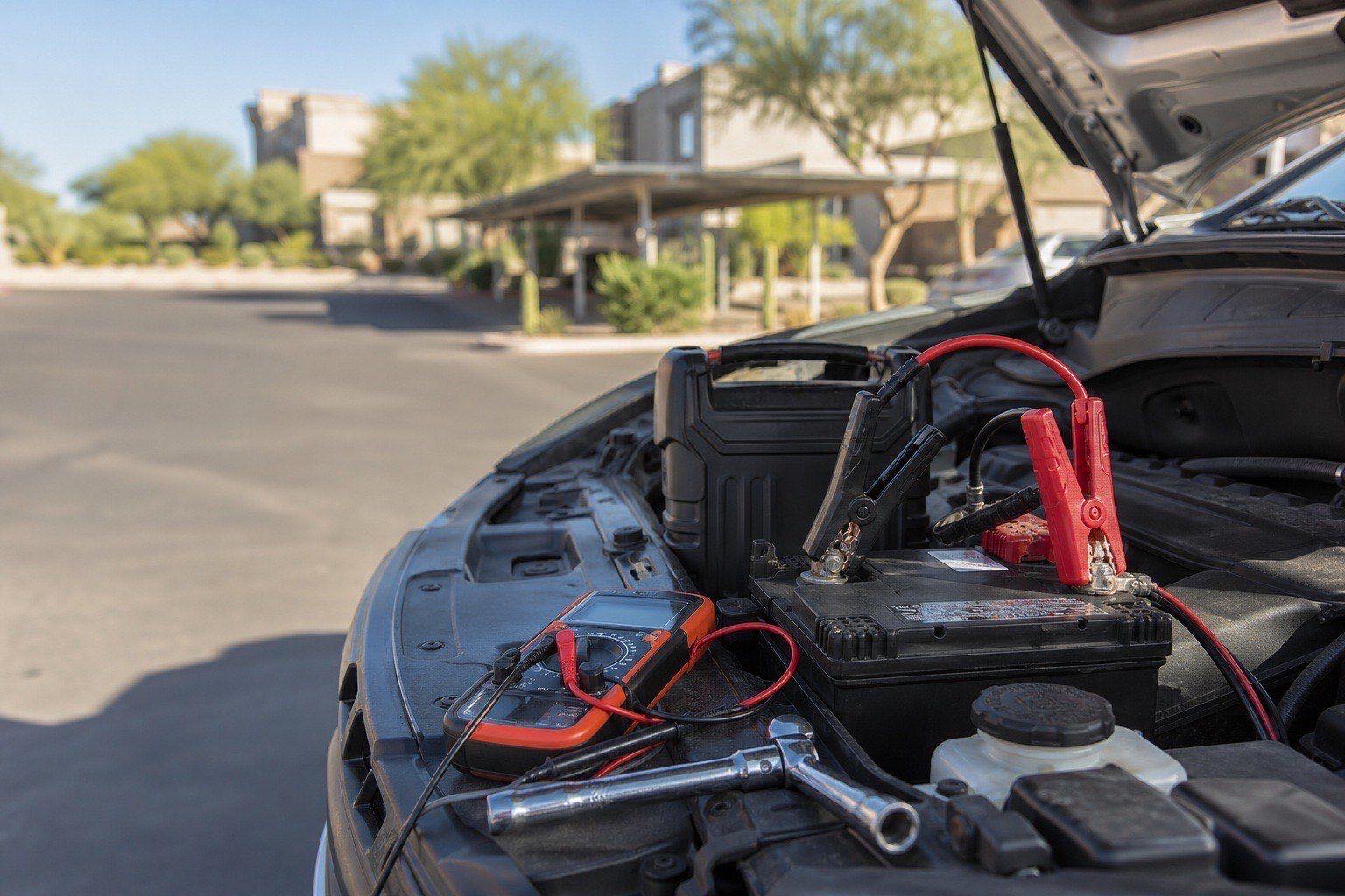 Denver mobile mechanic testing a battery at an apartment parking lot